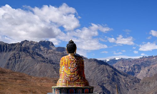 A serene Buddha statue sitting on a ledge, radiating tranquility and wisdom.